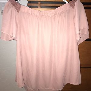 Off shoulder rose colored shirt.